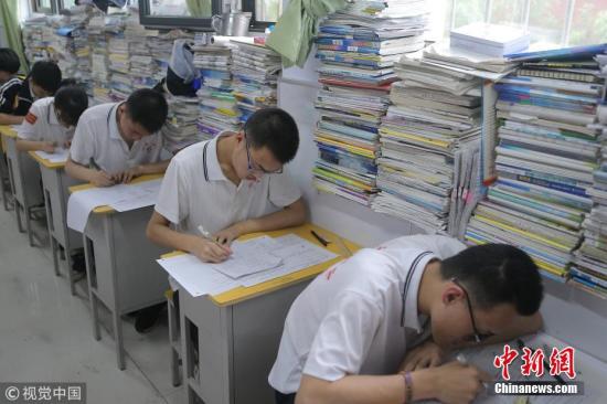 资料图：高三学生在教室内参加高考模拟考试，教室窗台上摆满了各种复习资料。 闫楠 摄 图片来源：视觉中国